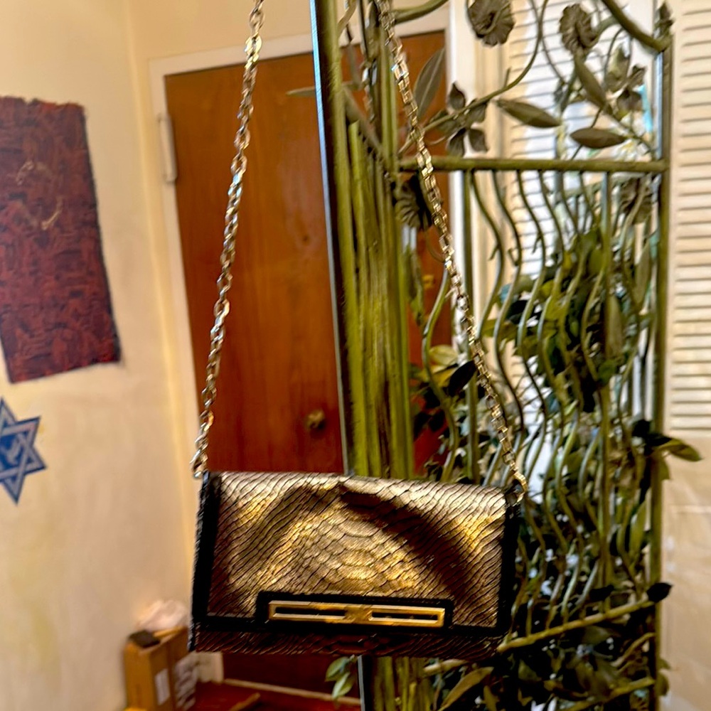 Nine West Silver, Snake print clutch.Frontal metal is rubbed.